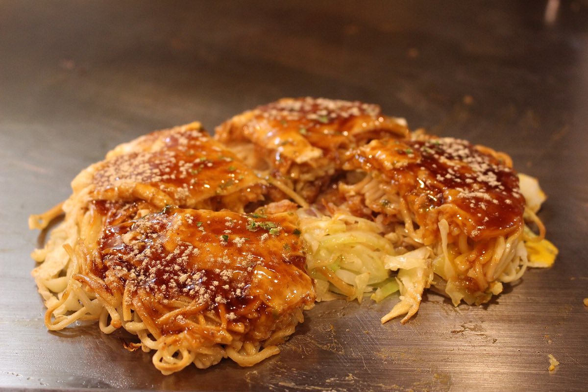 Hiroshima-style okonomiyaki cooking on the griddle